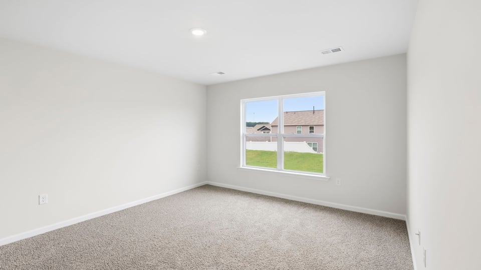 Bedroom with carpet and window.