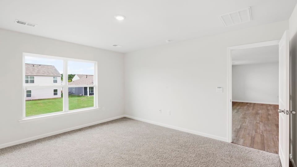 Bedroom with carpet and window.