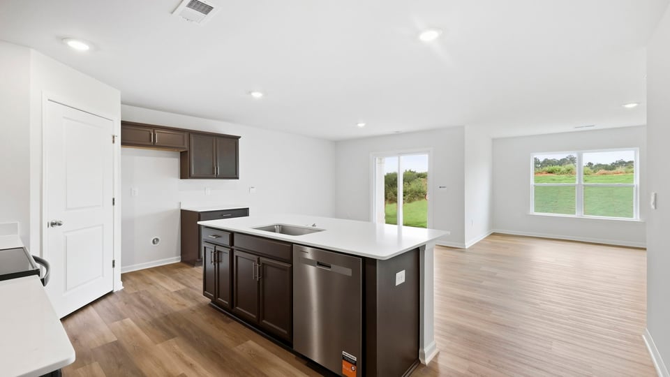 Kitchen and island with stainless steel appliances.