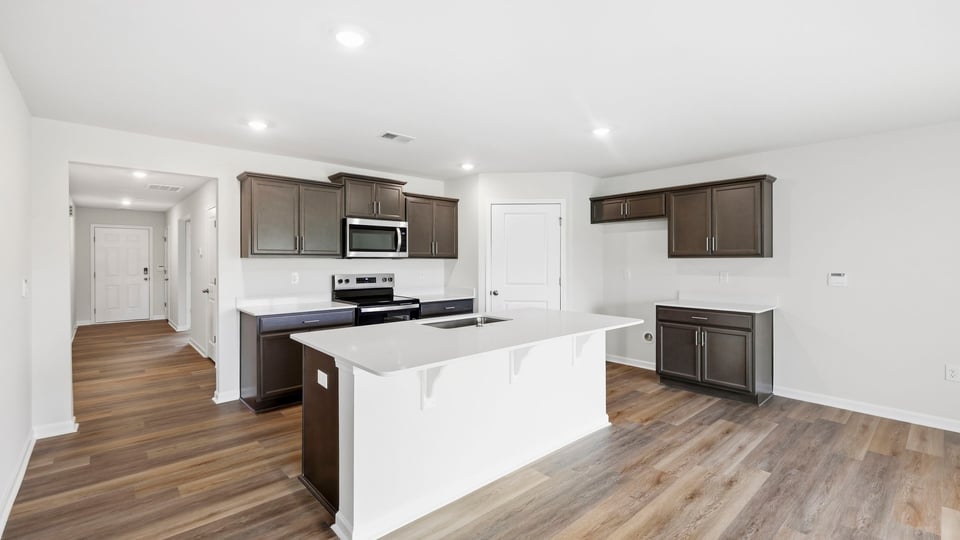 Kitchen and island with stainless steel appliances.