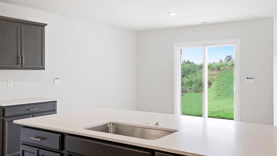 Kitchen and island with stainless steel appliances.