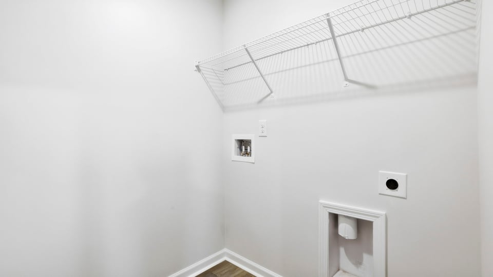 Laundry room with hanging storage racks.