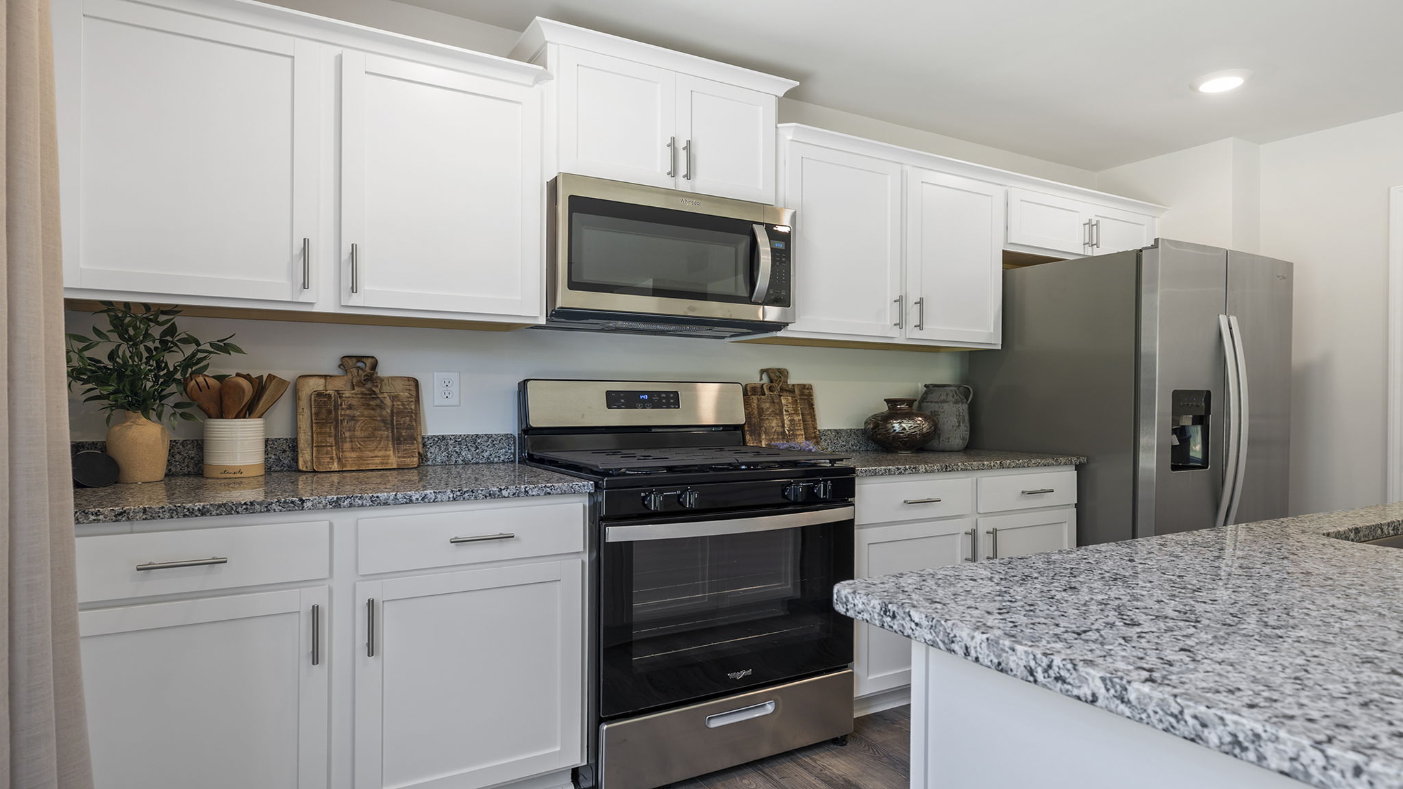 Kitchen and island with stainless steel appliances.