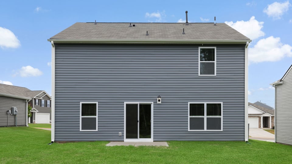 Back exterior of home with large backyard.