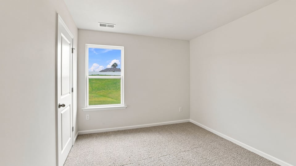 Bedroom with carpet and windows.