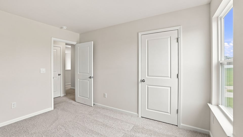 Bedroom with carpet and windows.