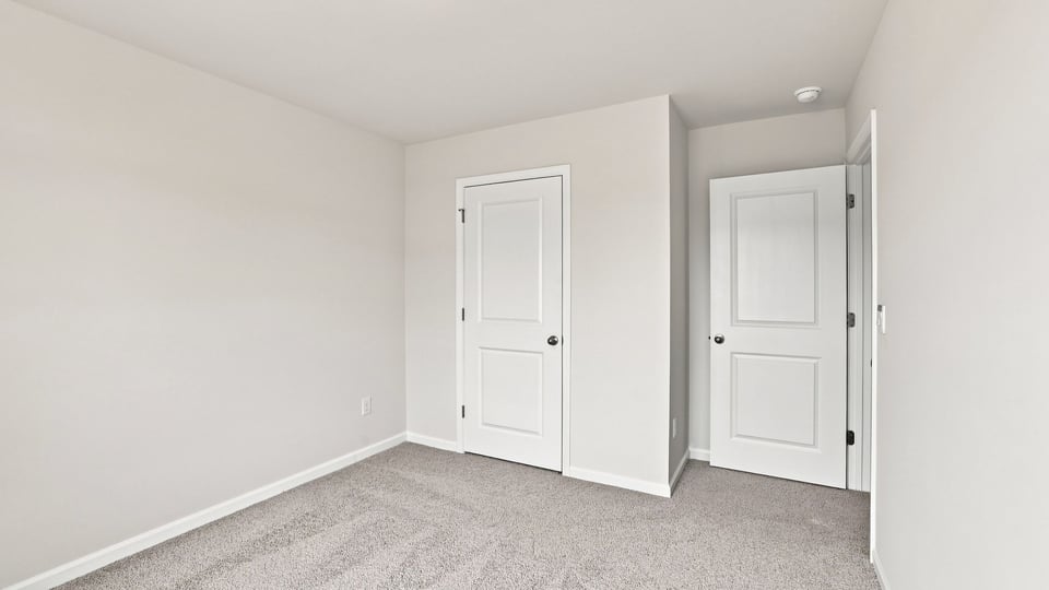 Bedroom with carpet and windows.