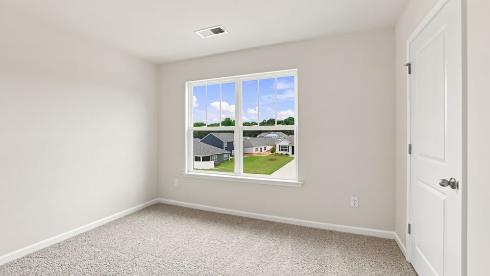 Bedroom with carpet and windows.