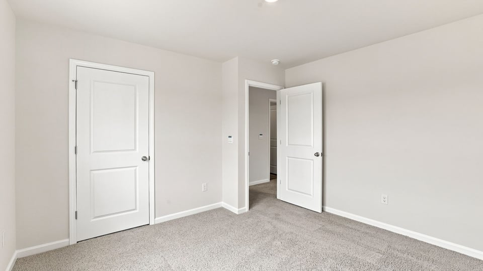 Bedroom with carpet and windows.
