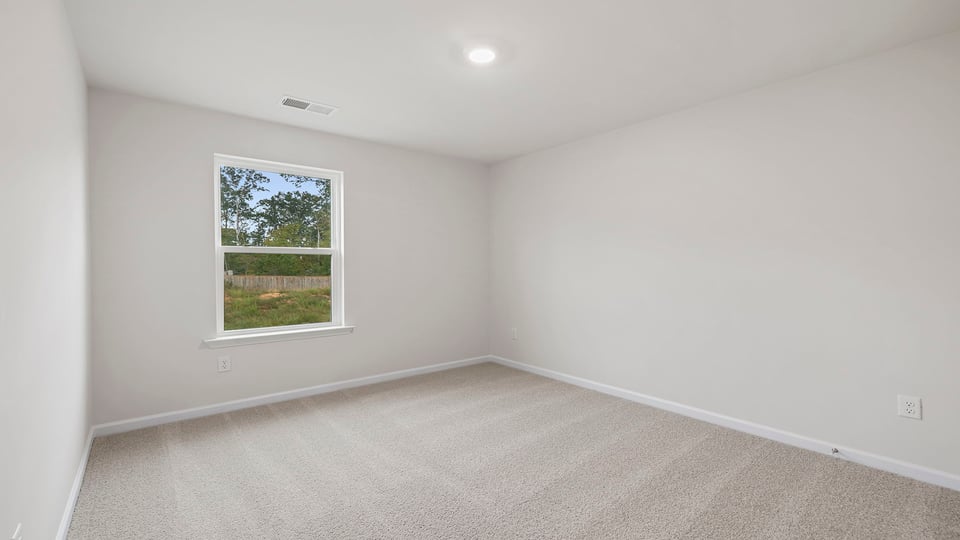 Bedroom with carpet and window.