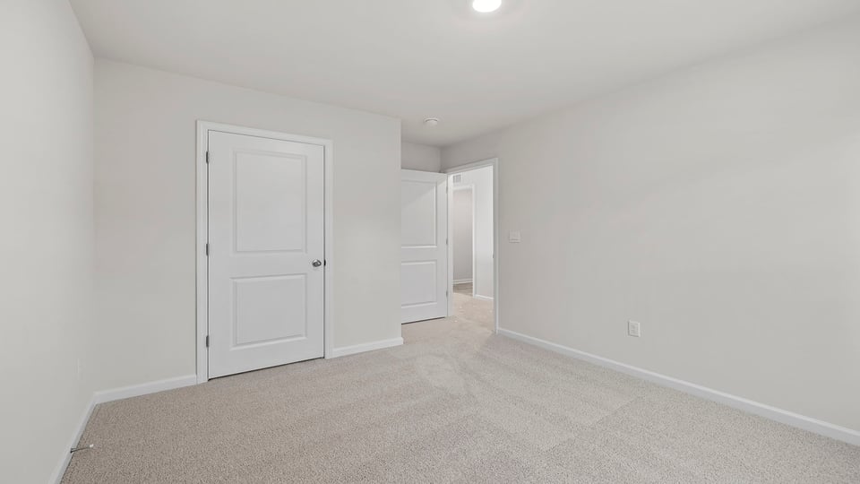 Bedroom with carpet and window.
