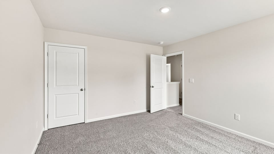 Bedroom with carpet and windows.