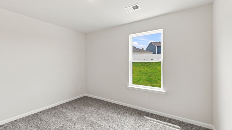 Bedroom with carpet and windows.