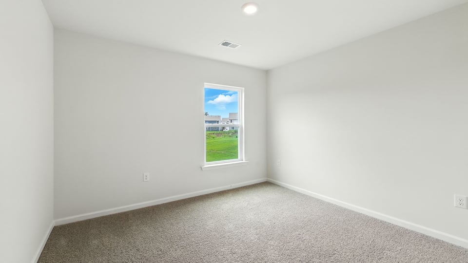 Bedroom with carpet and windows.