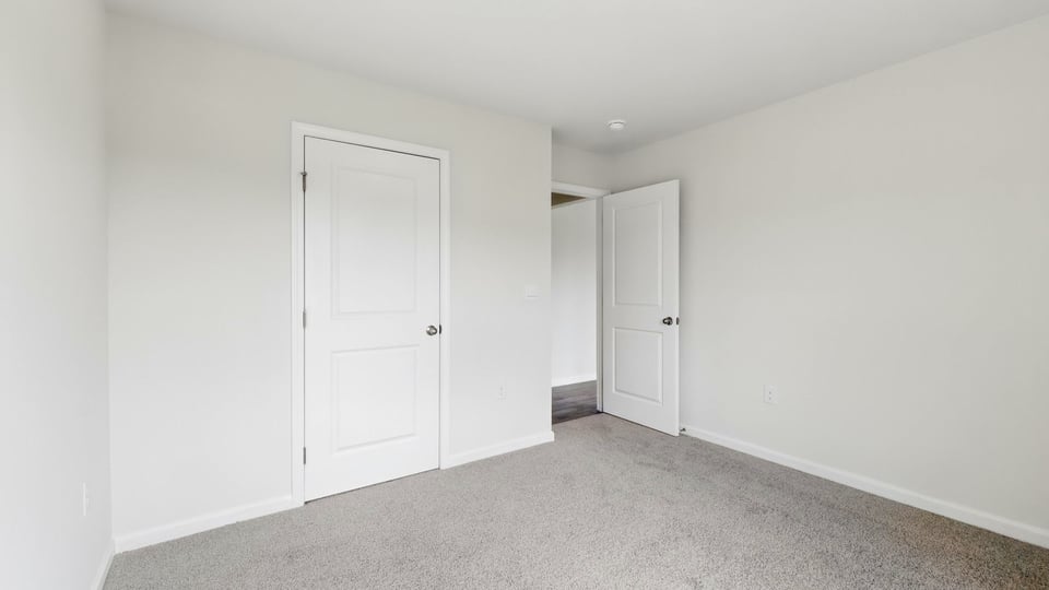 Bedroom with carpet and windows.
