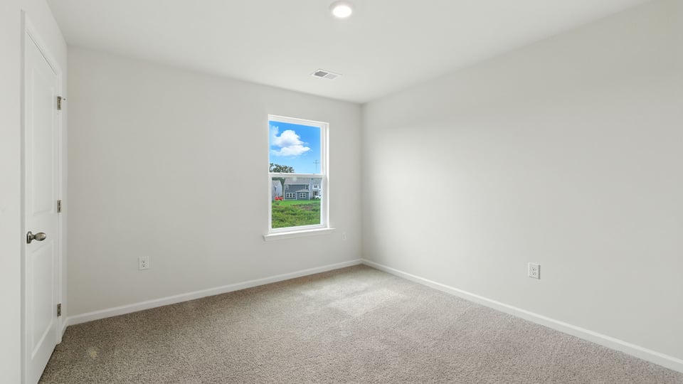 Bedroom with carpet and windows.