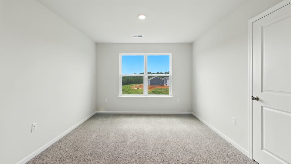 Bedroom with carpet and windows.
