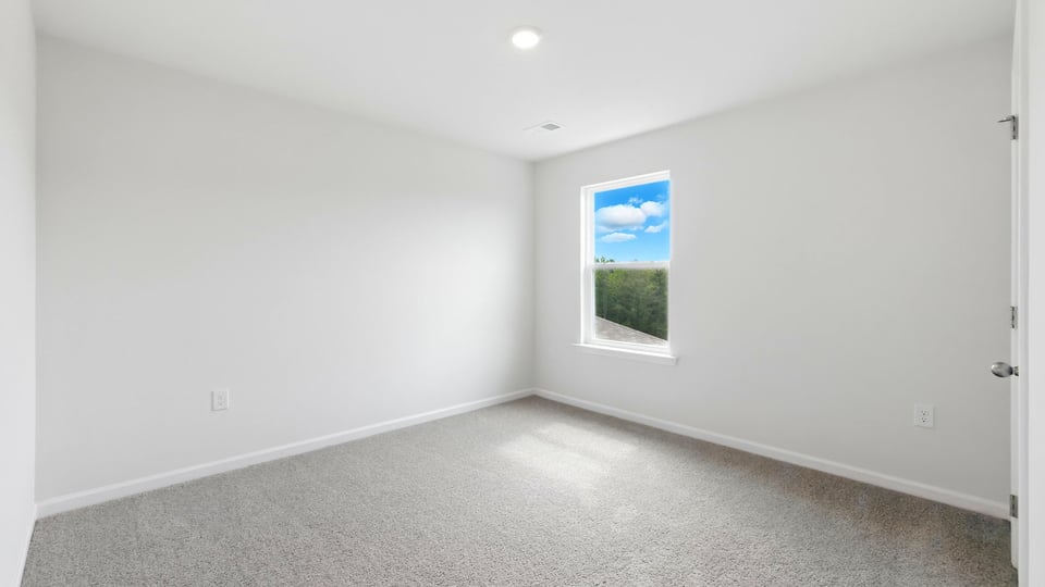 Bedroom with carpet and windows.