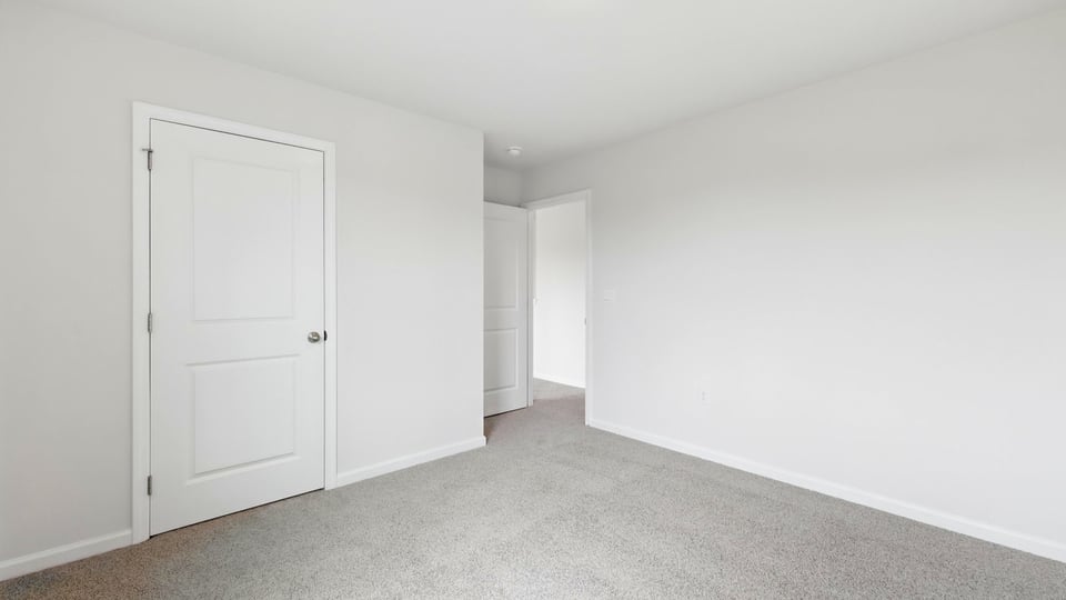 Bedroom with carpet and windows.