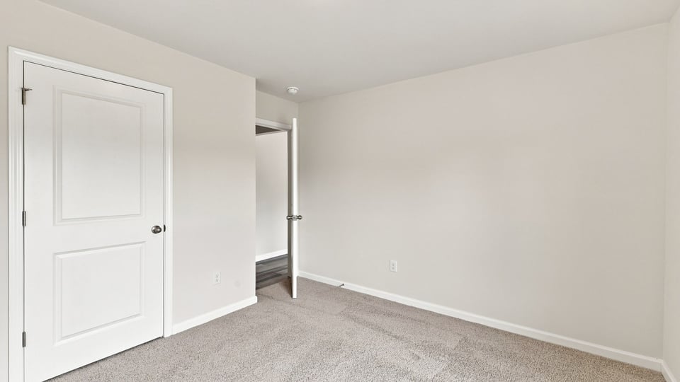 Bedroom with carpet and windows.