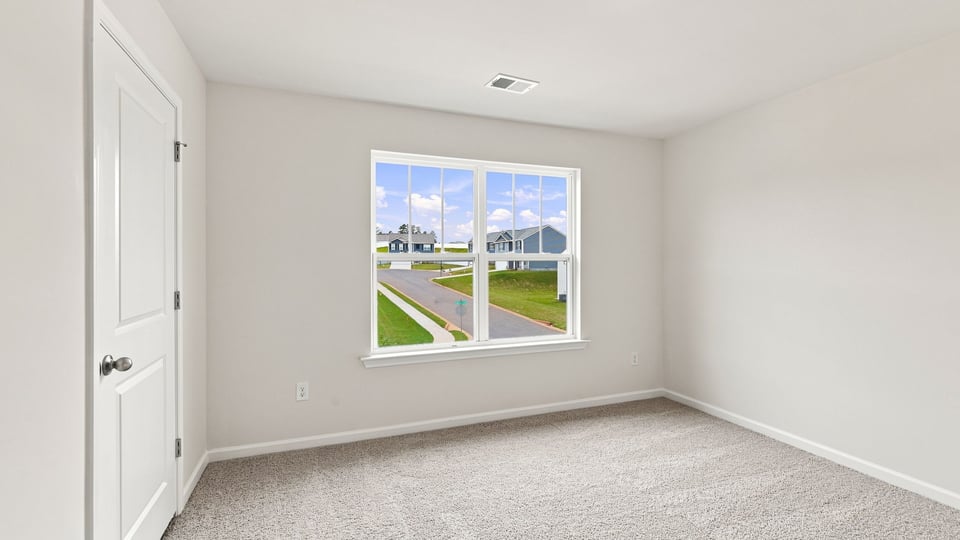 Bedroom with carpet and window.