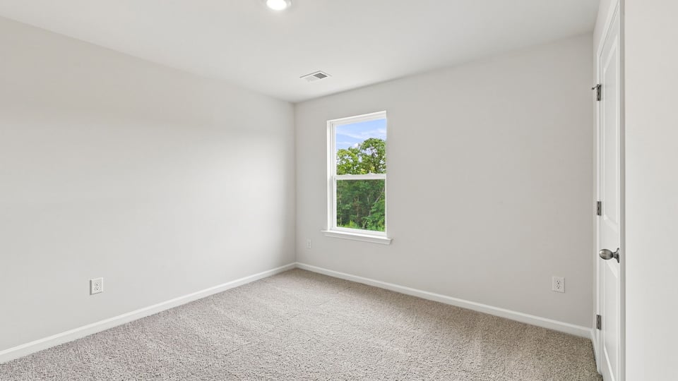 Bedroom with carpet and window.
