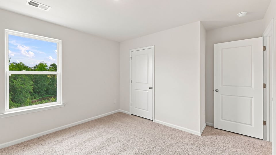 Bedroom with carpet and window.