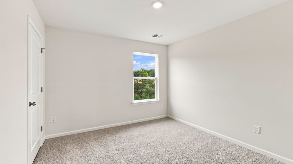 Bedroom with carpet and window.