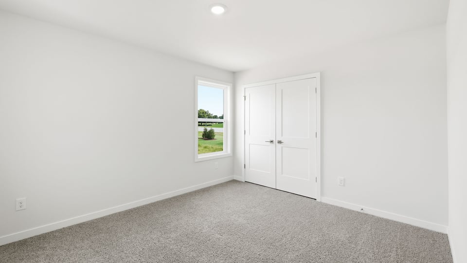 Bedroom with carpet and window.