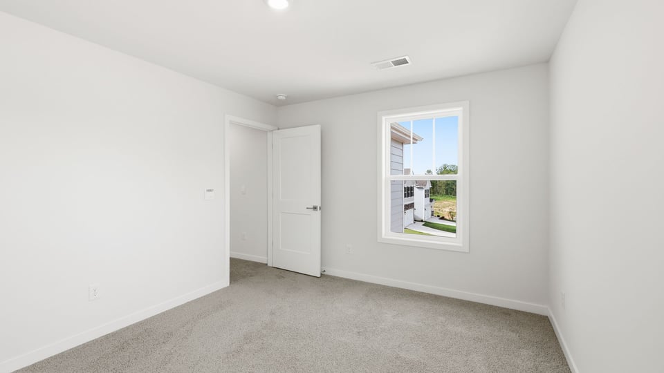 Bedroom with carpet and window.