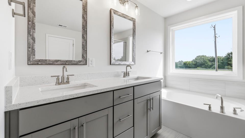 Bathroom with double vanity sink and bathtub.