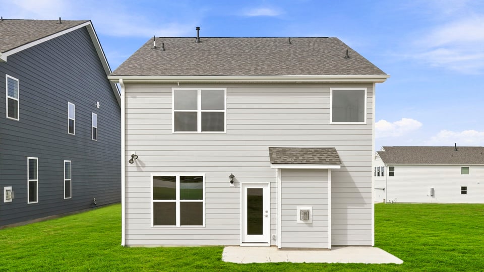 Back exterior of home with large backyard.
