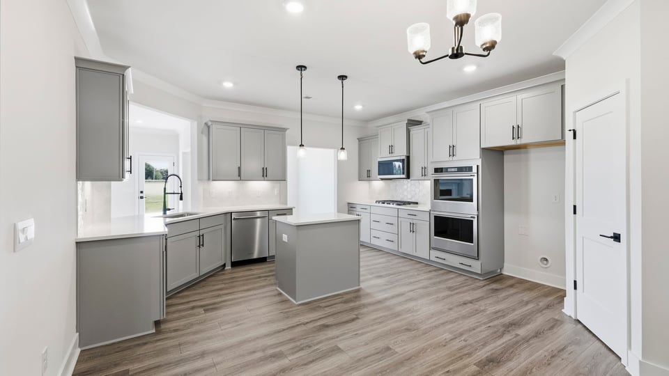 Kitchen and island with quartz countertops and stainless steel appliances.