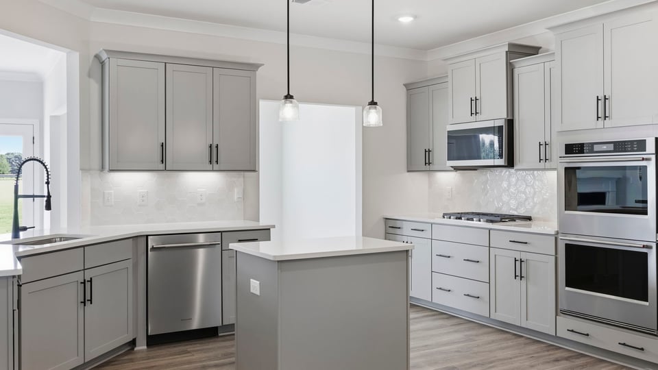 Kitchen and island with quartz countertops and stainless steel appliances.