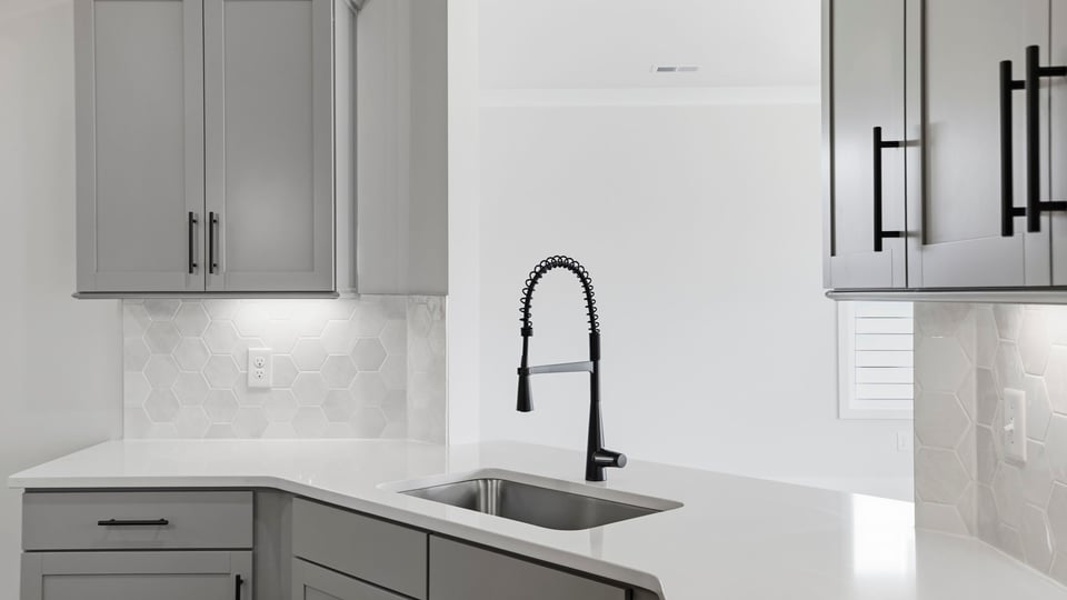 Kitchen and island with quartz countertops and stainless steel appliances.
