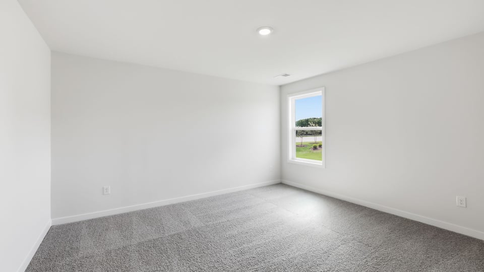 Bedroom with carpet and window.