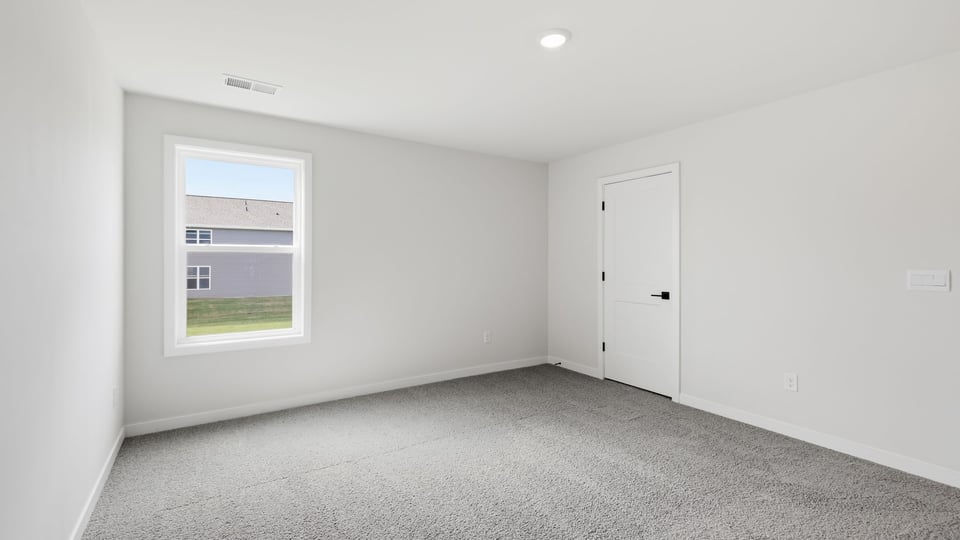 Bedroom with carpet and window.