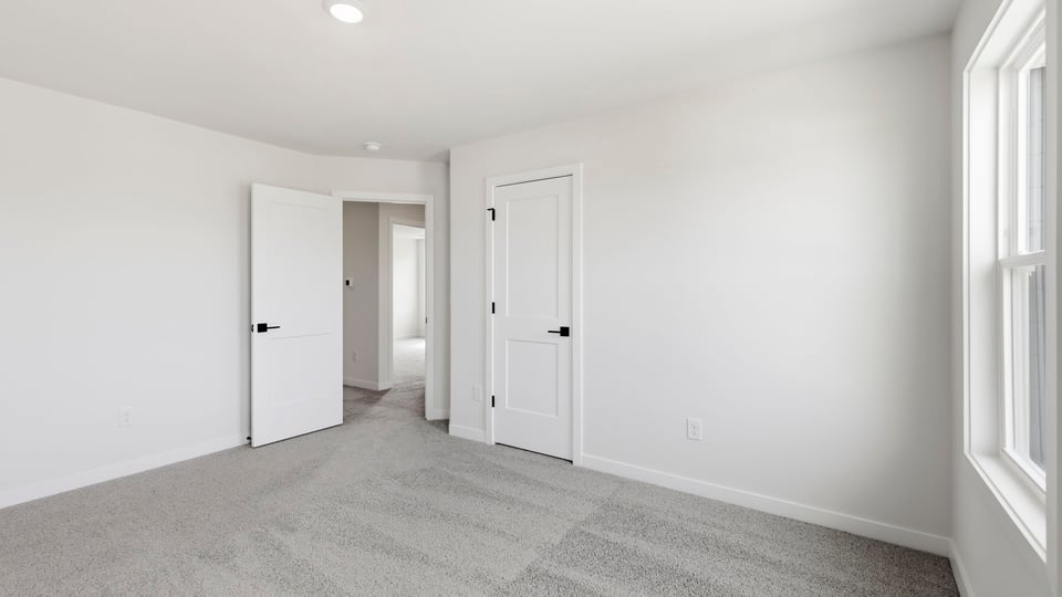 Bedroom with carpet and window.