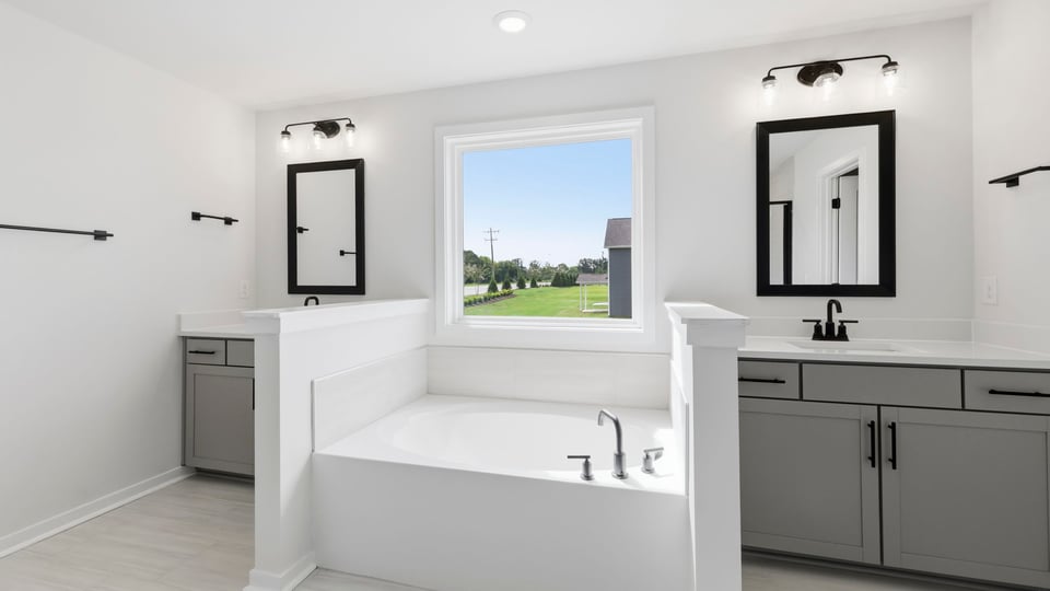 Bathroom with dual vanity sinks and bathtub.