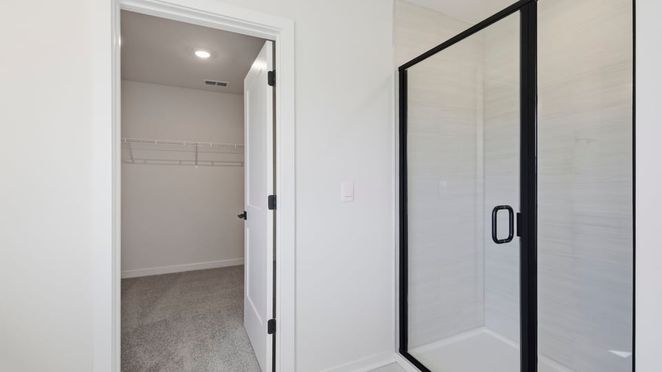 Bathroom with walk in shower and closet.