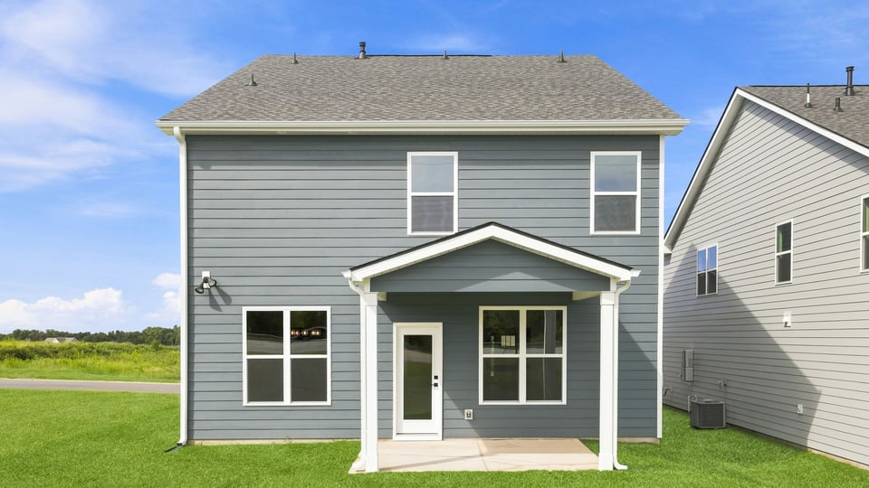 Back exterior of home with large backyard.