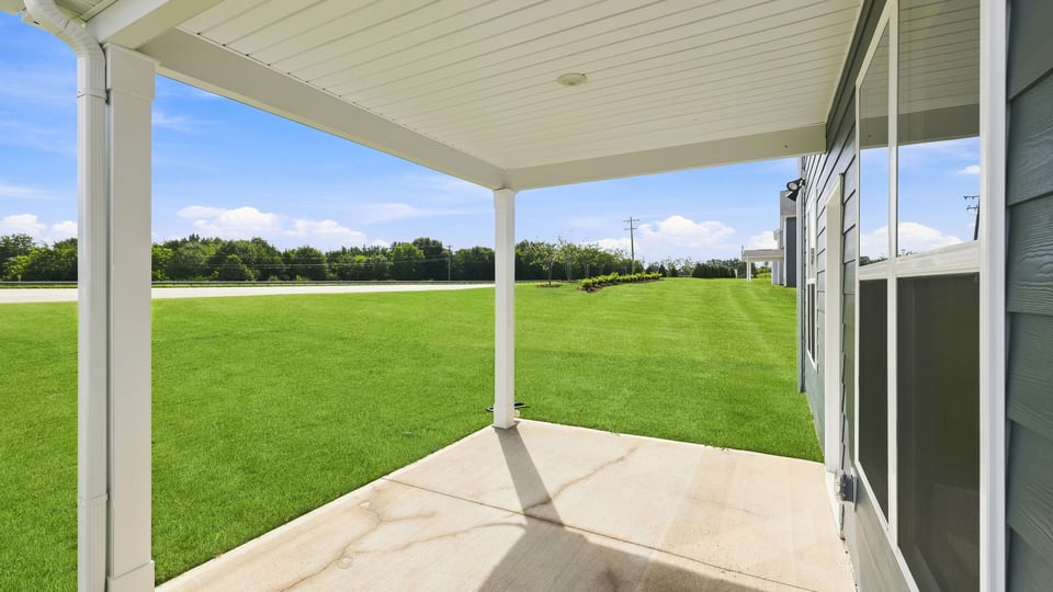 Back exterior of home with covered patio.