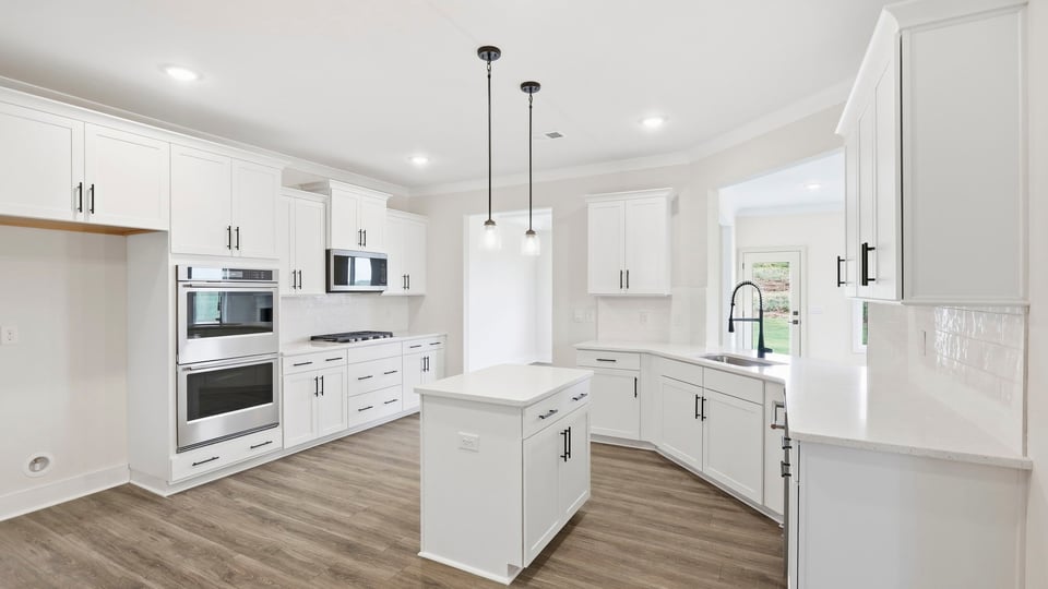 Kitchen and island with quartz countertops and stainless steel appliances.
