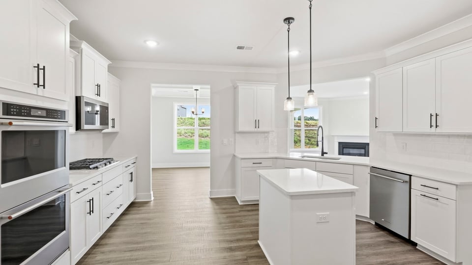 Kitchen and island with quartz countertops and stainless steel appliances.