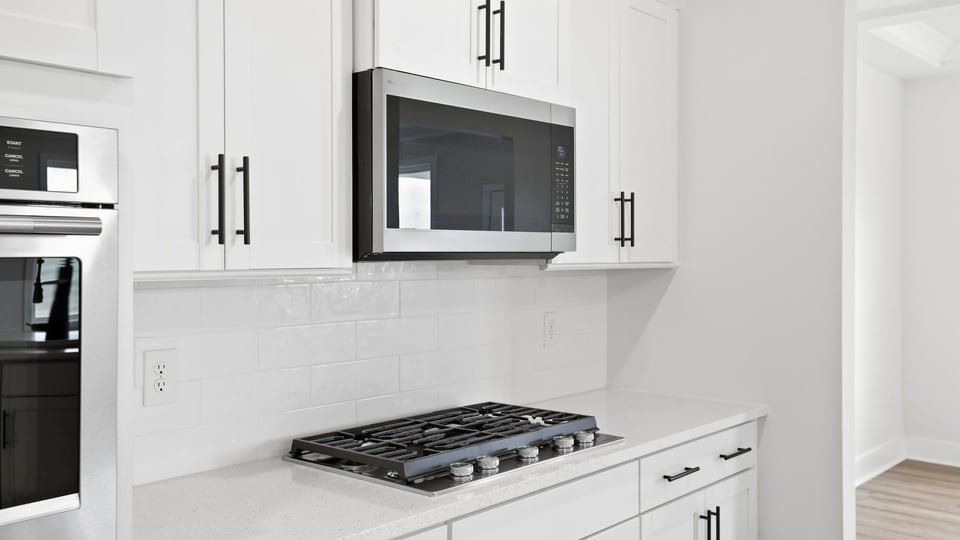 Kitchen and island with quartz countertops and stainless steel appliances.