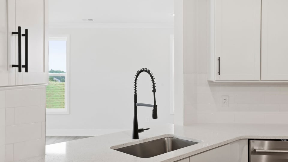 Kitchen and island with quartz countertops and stainless steel appliances.