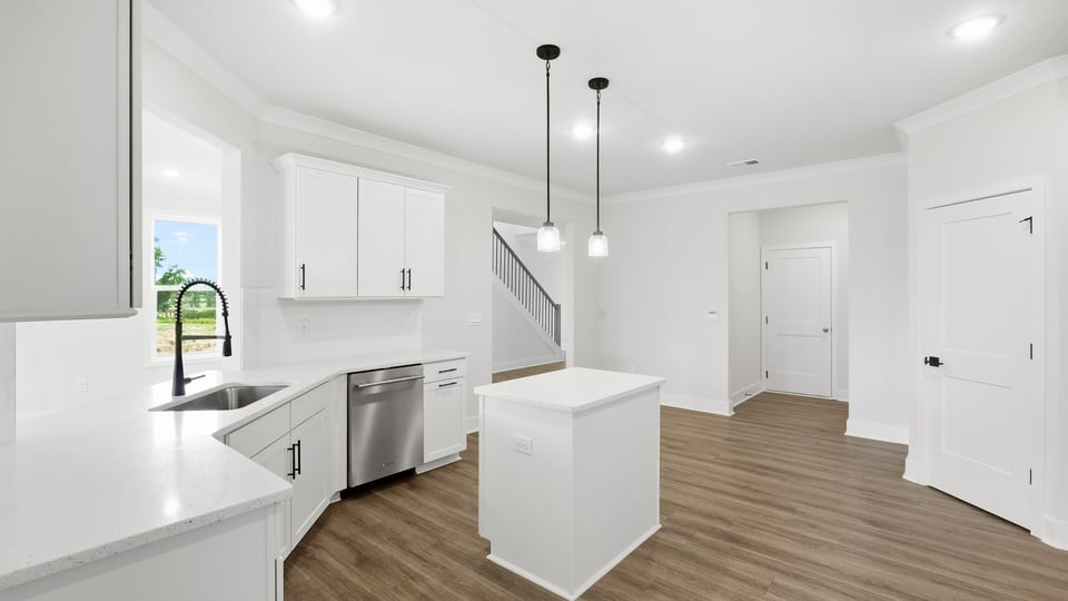 Kitchen and island with quartz countertops and stainless steel appliances.