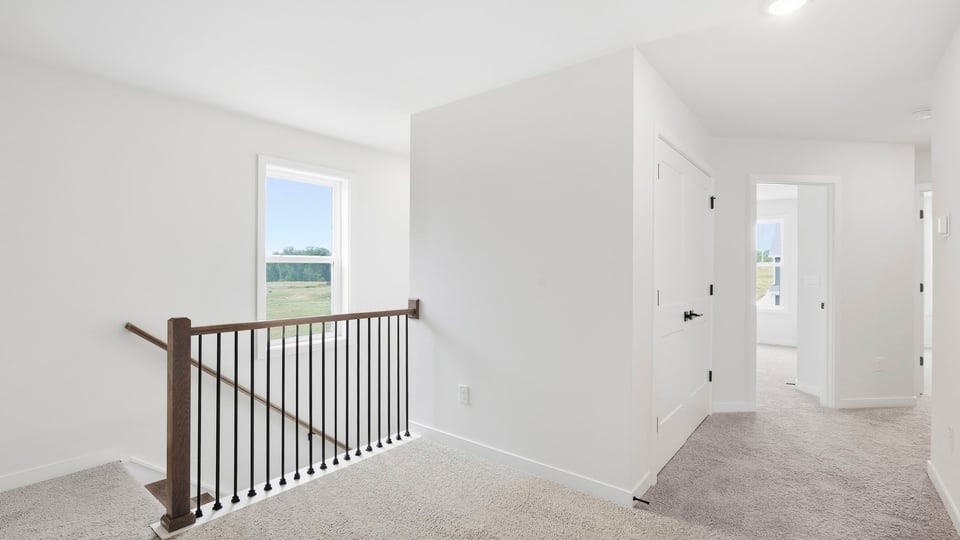 Loft area with carpet and windows.