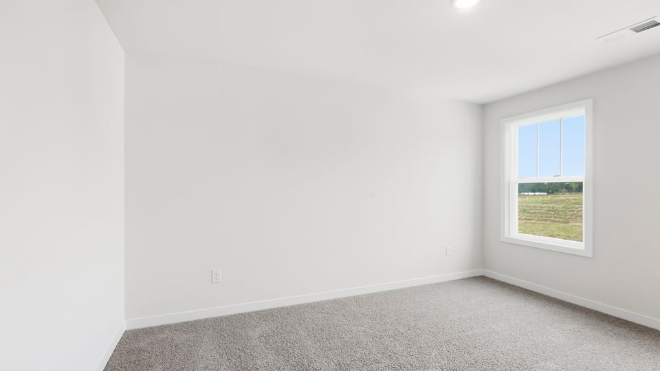 Bedroom with carpet and window.