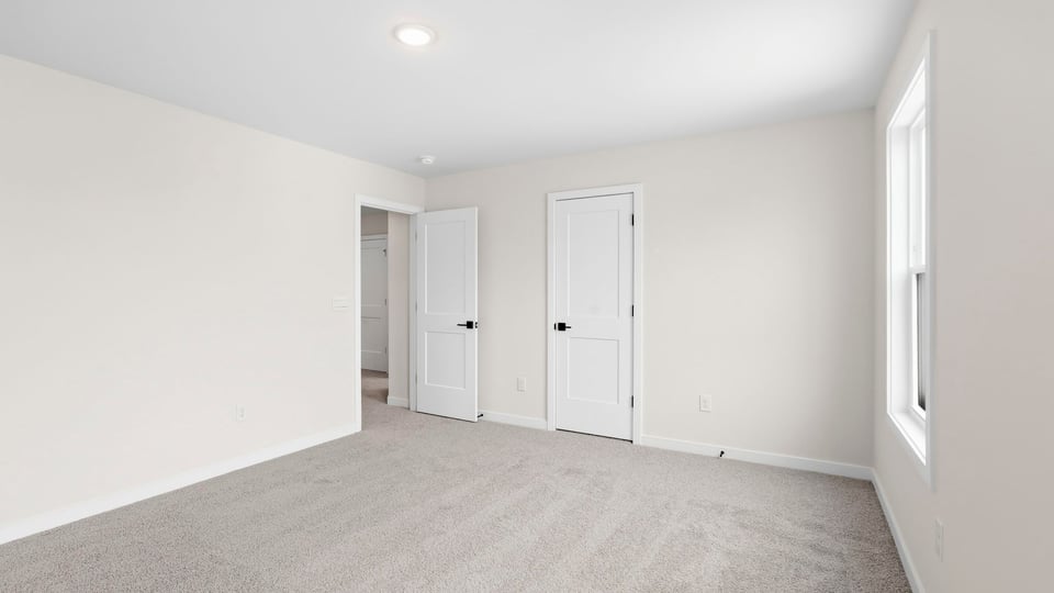 Bedroom with carpet and window.